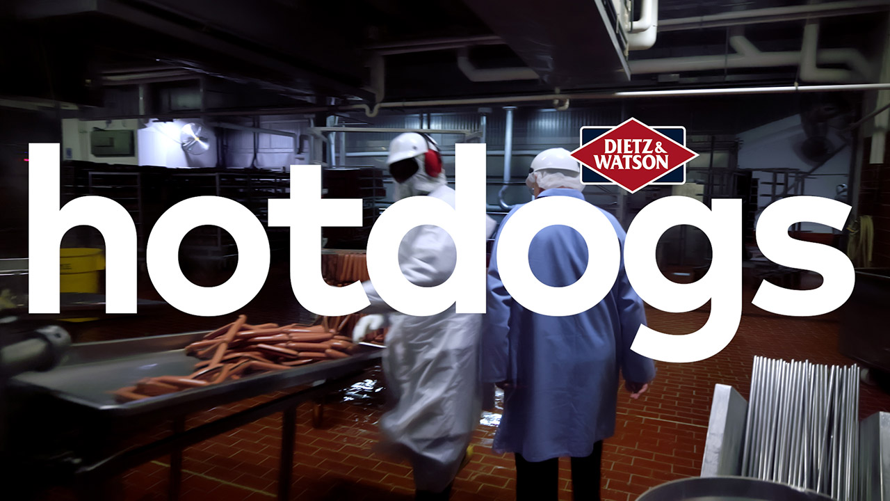 Dietz CEO, Louis, takes us through the hotdog peeling room where an employee feeds casings of hotdogs into a peeling machine.